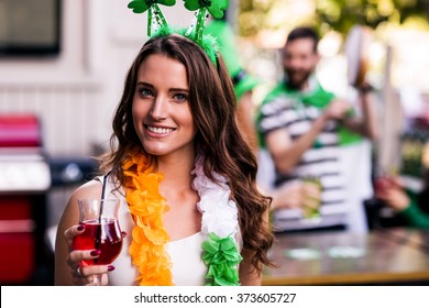 Portrait of woman celebrating St Patricks day with friends and drinks