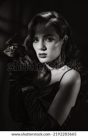 Portrait of woman in classic vintage noir image. Photo of girl in retro style of black and white Hollywood movies.