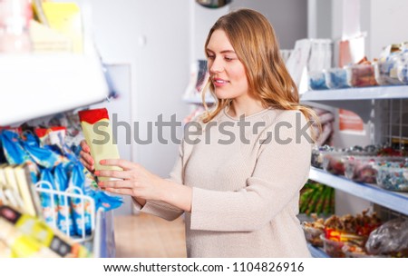 Portrait of  woman customer choosing spices in  grocery food shop