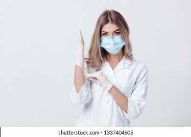 Portrait of woman doctor with face mask wearing white medical gloves - Shutterstock ID 1337404505