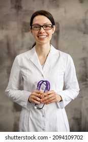 Portrait Of A Woman Doctor With Stetoscope Looking At Camera. Smiling Female Doctor In A Clinic Background.