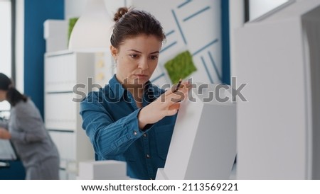 Portrait of woman engineer analyzing building model and structure to design construction plan. Close up of architect using maquette to create urban layout and property development. [[stock_photo]] © 