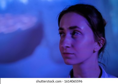 Portrait Of Woman Face Looking Around At Modern Immersive Exhibition With Low Light Illumination And Colorful Video Art Installation. Education, Digital Art And Entertainment Concept