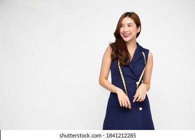 Portrait of a woman fashion designer clothes in deep blue dress with measuring tape isolated over white background, Asian female stylish model - Powered by Shutterstock