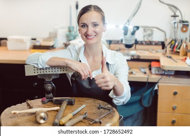 Portrait Of A Woman Goldsmith In Her Workshop Standing Amidst Tools