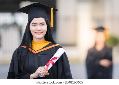 Portrait of a woman graduate holds a diploma degree certificate in the graduation ceremony