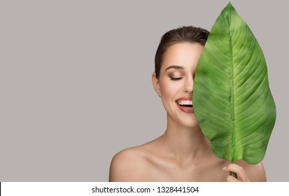 Portrait Of Woman And Green Leaf. Organic Beauty. Gray Background.