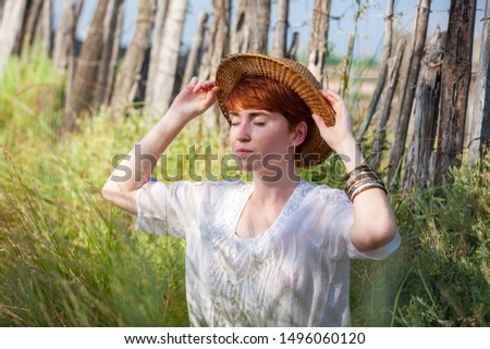 PORTRAIT OF WOMAN WITH A HAT OF STRAW OUTDOOR
