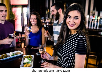 Portrait of woman having an aperitif with friends in a bar