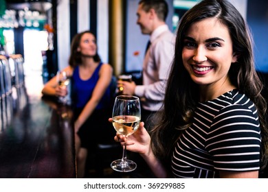 Portrait of woman having a drink with friends in a bar