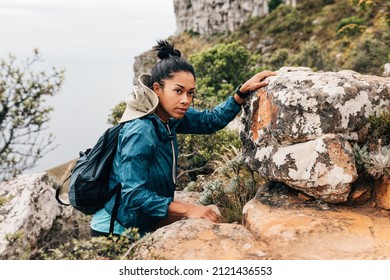 Portrait Of Woman Hiker Climbing Rock And Looking Away. Young Female Hiking Mountain.