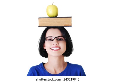 Portrait of a woman holding book and apple on head.