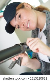 Portrait Of Woman Holding Caulk Gun