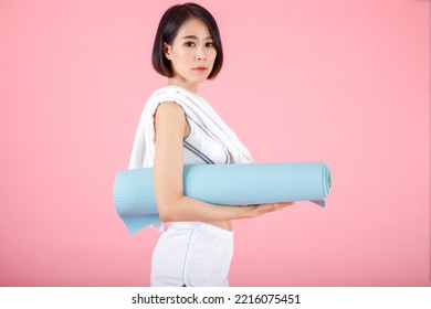 Portrait Of Woman Holding Exercise Mat Roll, Holding Yoga Mat Roll On Pastel Pink Background.