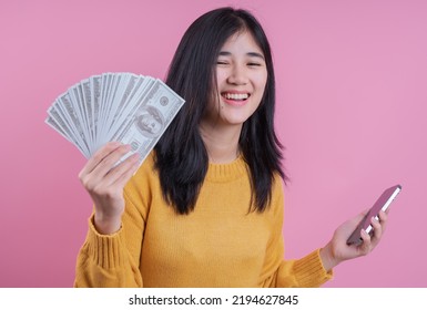 Portrait Of Woman Holding Fan Of 100 Dollar Bills And Smartphone In Hands In Delight, Being Crazy With Lots Of Money