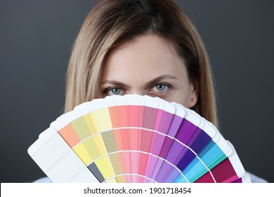 Portrait of woman holding fan of color palette. Selection by stylist of the color scheme concept - Powered by Shutterstock