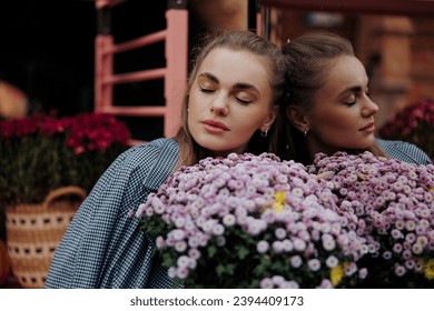 Portrait of woman holding flowers bouquet and enjoying by it with closed eyes at florist store near her reflection in mirror. Customer, buyer. Saleswoman. Woman florist. Small business. Floral shop. - Shutterstock ID 2394409173