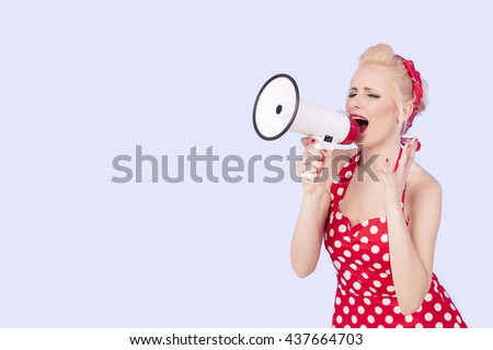 Portrait of woman holding megaphone, dressed in pin-up style red dress 