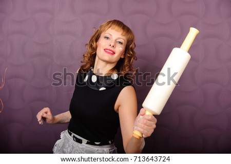 Portrait of a woman holding a rolling pin and smiling