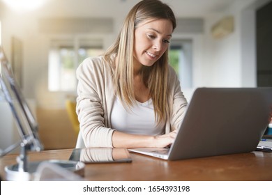 Porträt von Frau zu Hause mit Laptop verbunden