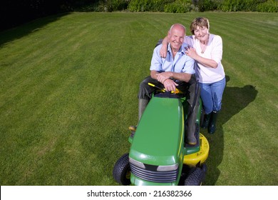 Portrait Of Woman Hugging Man On Riding Lawn Mower