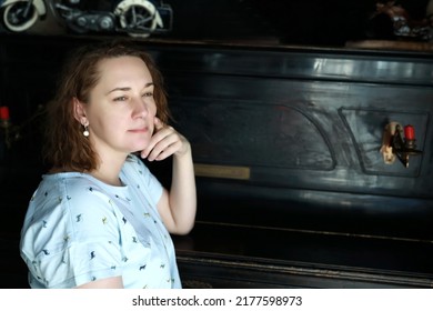 Portrait of woman leaned on vintage piano