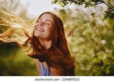 Portrait of a woman with long flyaway hair red hair in summer, the concept of health and care for long thick hair beauty - Powered by Shutterstock