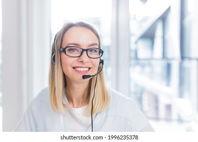 portrait of a woman looking at the camera, young blonde woman with headset and glasses communicates with customers, online consumer support, call center, conference, help close up - Powered by Shutterstock