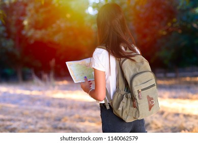 Portrait Of A Woman Looking Forward At Sunset Outdoor. Personal Development, Attainment Motivation Career Growth Concept. Portrait Of Beautiful Girl Tourist With Backpack Holding Travel Guide Book.