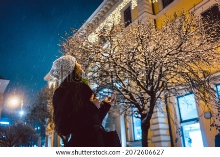 Portrait of woman looking at sparkling snowfall