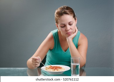 Portrait of woman with no appetite in front of the meal. Concept of loss of appetite