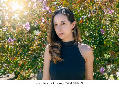 Portrait Of Woman On Flower Background. Beautiful Girl Dressed With A Black Turtle Neck Blouse