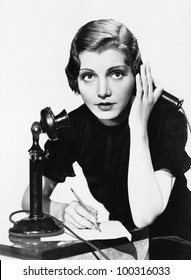 Portrait of woman on telephone taking notes