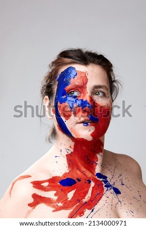 Portrait of a woman with a painted face. Creative makeup and bright style.Girl with colored face painted. Art beauty image.girl with colorful paint on her face. 