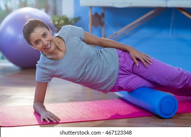 Portrait Of Woman Performing Exercise Using Foam Roll In The Clinic