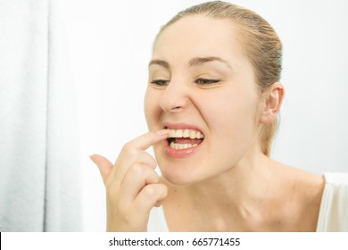 Portrait Of Woman Picking Food Stuck In Teeth With Finger