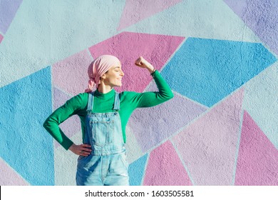 Portrait of woman with pink headscarf, has cancer. Show the arm as a signal of strength - Powered by Shutterstock