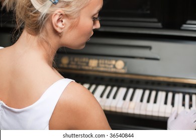 Portrait of woman playing on the retro style piano. Old museum piano with date inscription of 1882 edition. Not copyrighted now