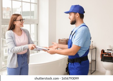 Portrait Of Woman And Plumber In Bathroom