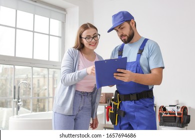 Portrait Of Woman And Plumber In Bathroom