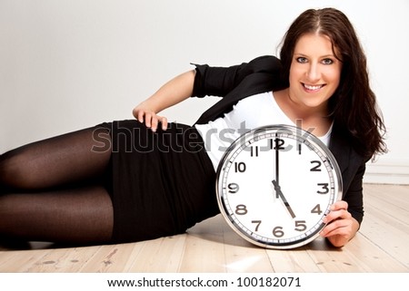 Portrait of a woman posing while holding a clock against white background