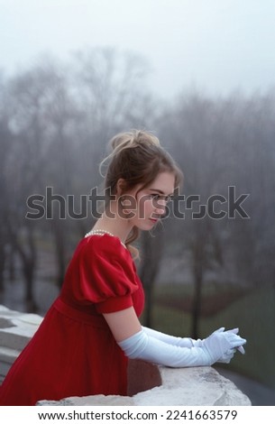 Portrait of woman in red dress from 19th century at home balcony looking into the distance