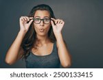 Portrait, woman and shocked with glasses in studio for space, eye care and lens vision of prescription frame. Girl, surprise and eyewear discount for consultation, ophthalmology and grey background