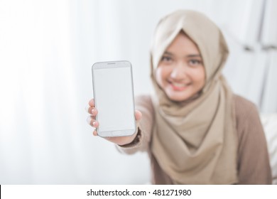 Portrait Of Woman Showing And Presenting Mobile Phone Screen And Smile To Camera