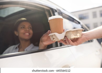 Portrait Of Woman Sitting In Car And Buying Coffee To Go