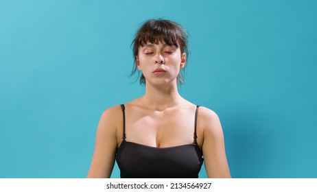 Portrait Of Woman Sitting With Eyes Closed And Taking Deep Breaths, Relaxing And Meditating After Intense Workout Exercise. Athletic Person Doing Yoga Meditation To Recover From Gymnastics.