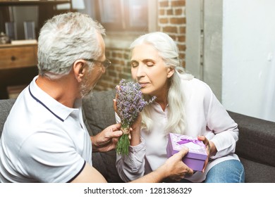 portrait of woman smelling bouquet of lavender in mans hands at home - Powered by Shutterstock