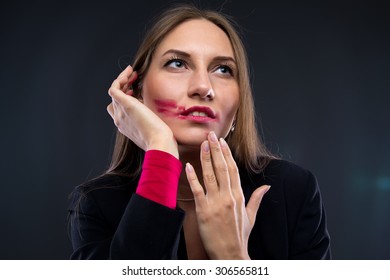 Portrait Of Woman With Smudged Red Lipstick, Looking Up On Black Background