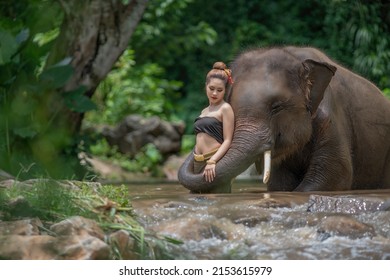 Portrait Of A Woman Standing In A River With An Elephant, Thailand
