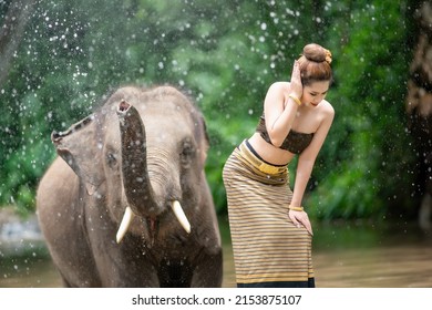 Portrait Of A Woman Standing In A River With An Elephant, Thailand.

